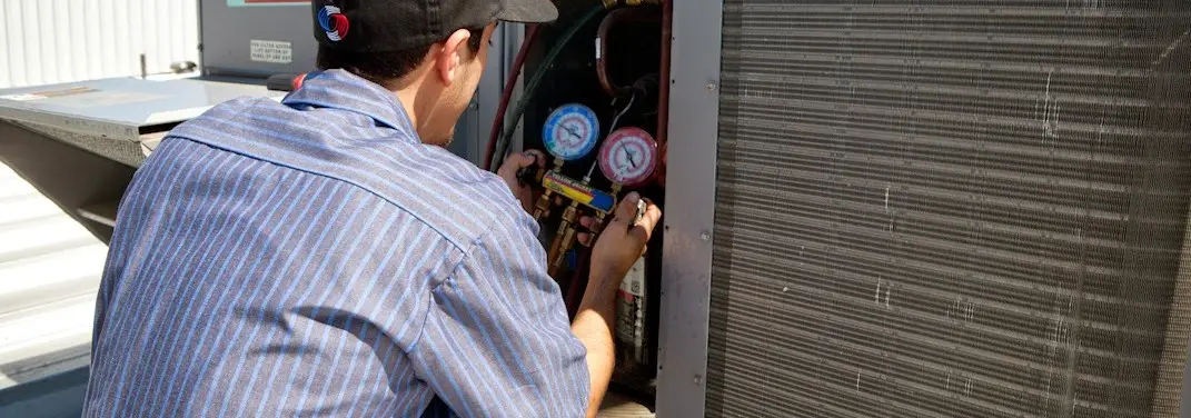 HVAC technician servicing a condenser unit in Camarillo